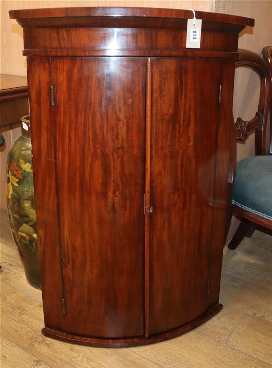 A George III mahogany bow front hanging corner cabinet H.100cm